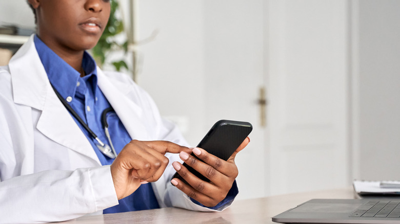Doctor looking at cell phone