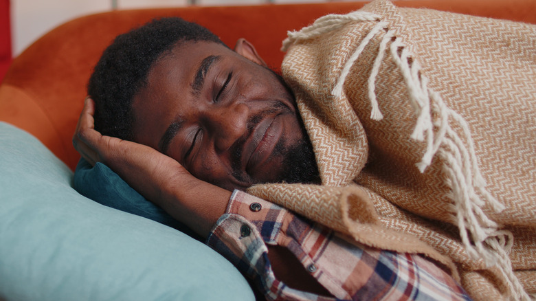 Smiling man napping on couch