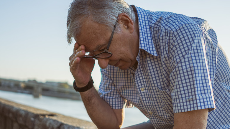 Elderly man outside with headache
