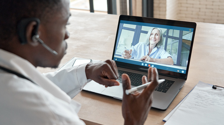 African American doctor meeting with older woman via telehealth