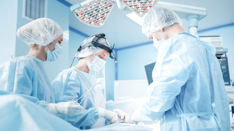 Three doctors performing a surgery in an operation room