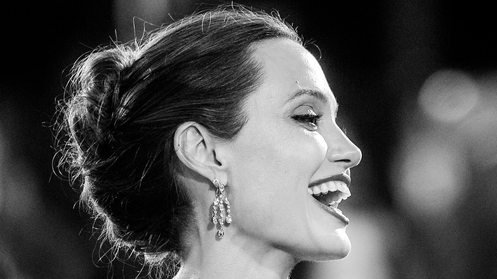 A black and white photograph of Angelina Jolie smiling