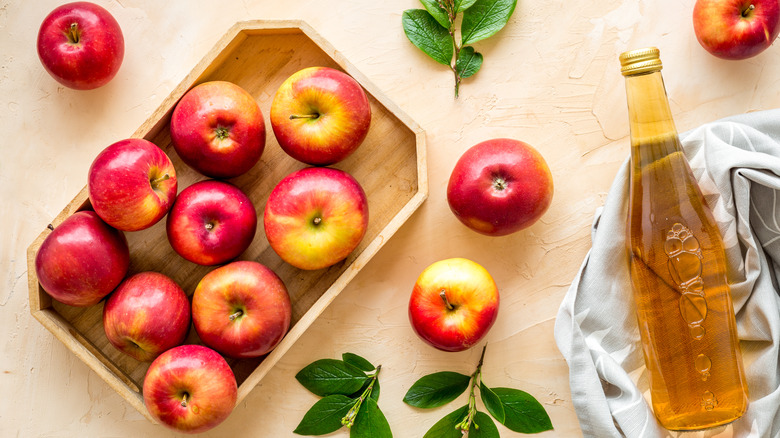 Apples beside bottle of cider vinegar