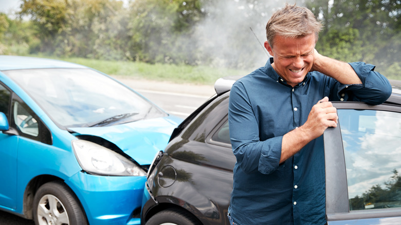 man holding neck after car crash