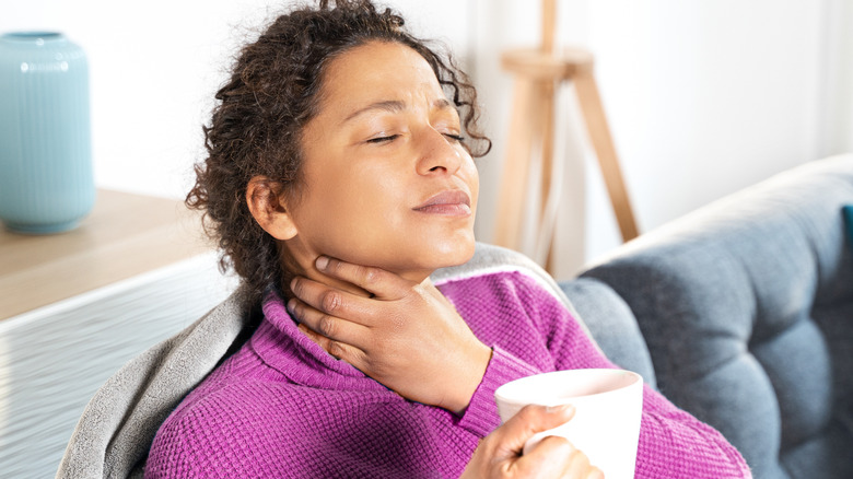 Woman touching her sore throat