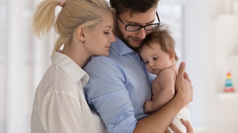 young parents cuddling baby