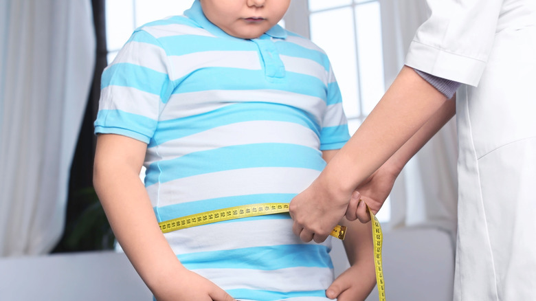 doctor measuring child's waistline