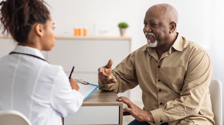 Older man speaking to doctor