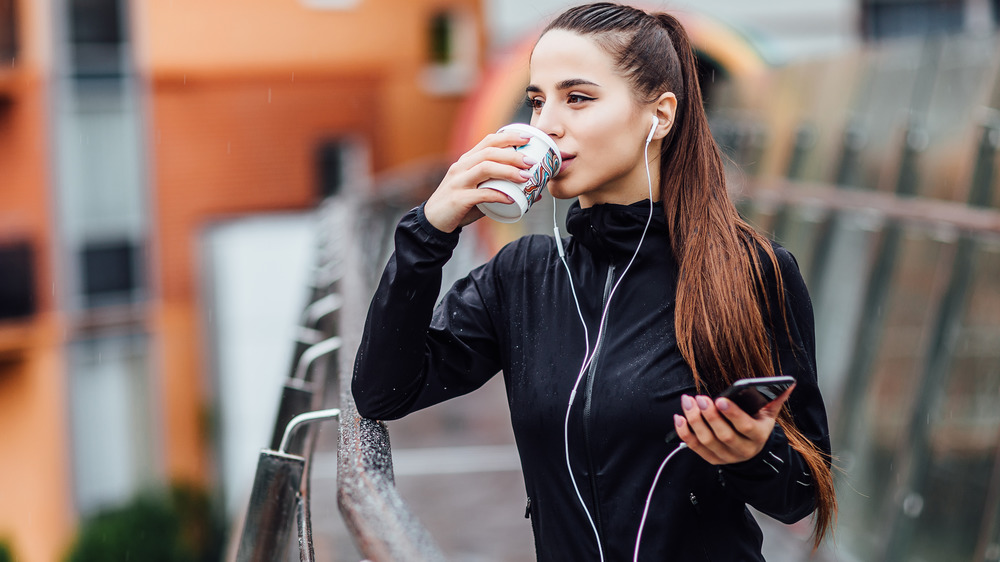 Woman drinking coffee while running