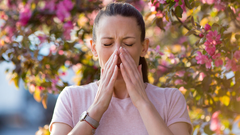 Woman sneezing outside