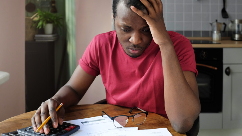 Man looking at bills anxiously