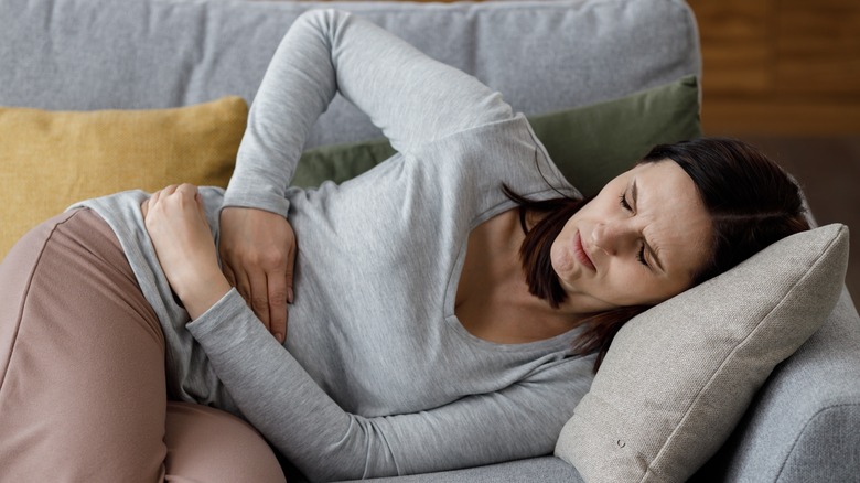 Woman in bed holding belly