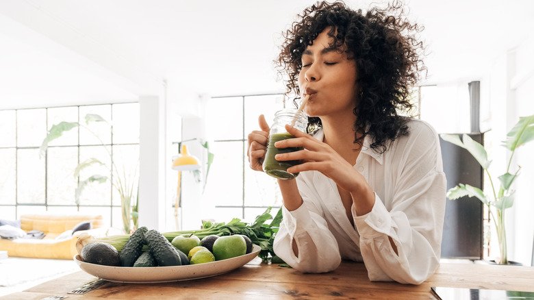 woman drinking green smoothie