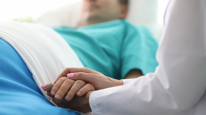 Doctor holding a patient's arm in the hospital