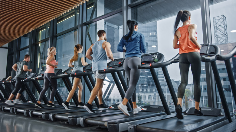 People exercising on treadmills at gym