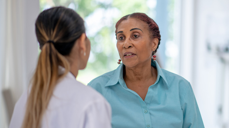 A woman talking with her doctor in an exam room