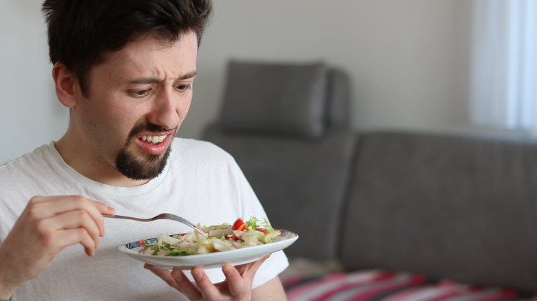 man disgusted by salad