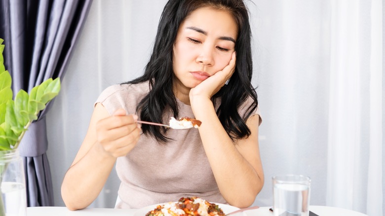 unhappy woman looking at food