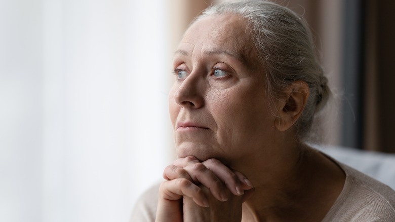 Depressed woman clasping hands