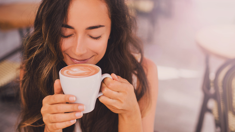 Women smelling cup of coffee