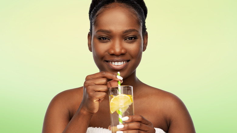 Woman smiling drinking lemon water