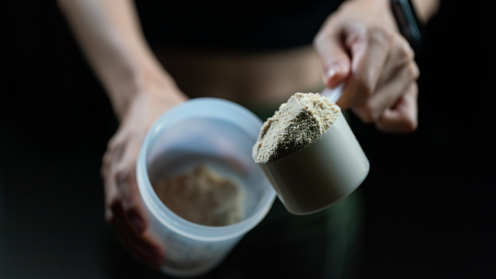 Close-up of hands and protein powder