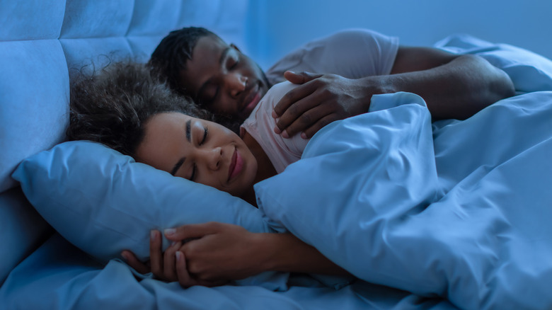 A man and woman in bed sleeping