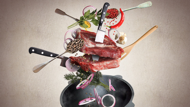 meat and other ingredients being falling into a wok 