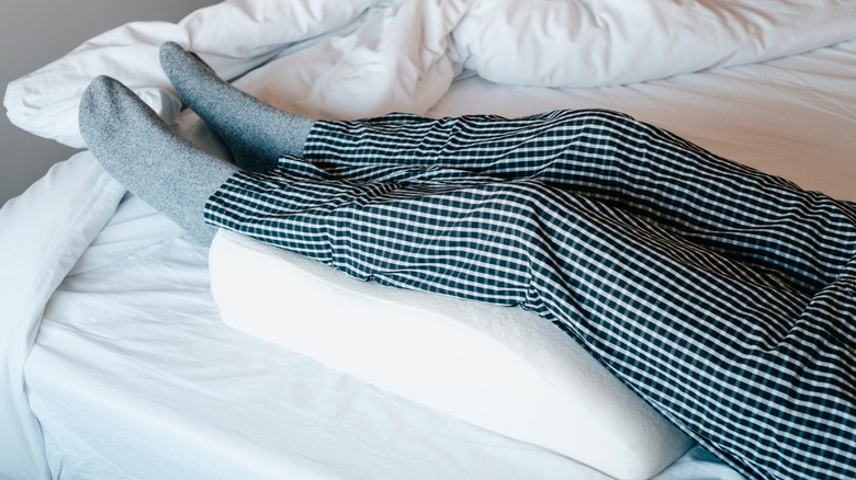 man using leg elevation pillow