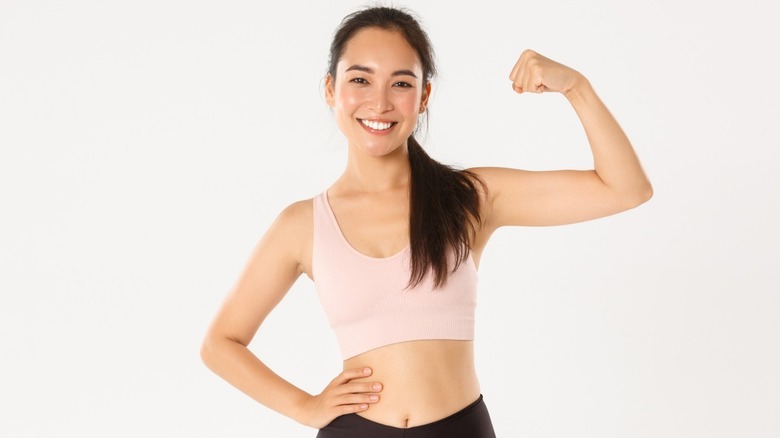 athletic woman flexes bicep