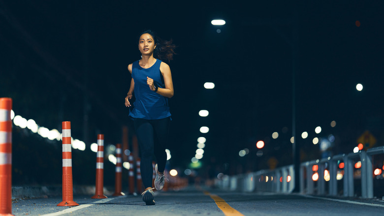 A woman runs at night