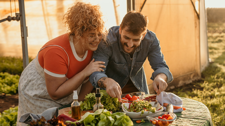 couple preparing vegetables on table