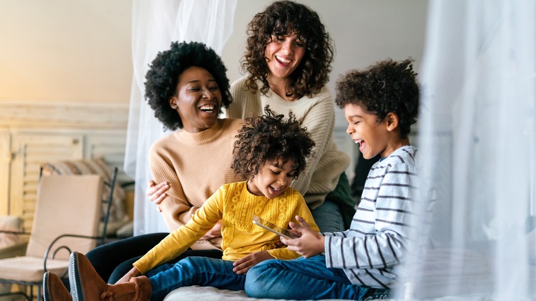 laughing family sitting on bed
