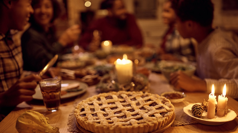 family at holiday table featuring pie in foreground