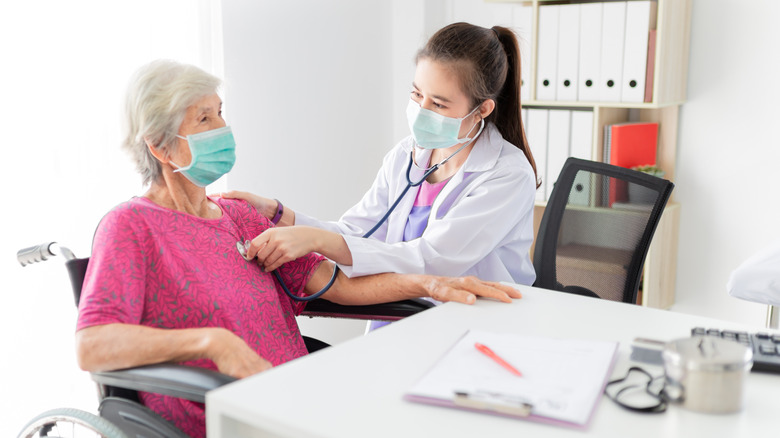 A doctor examines the lungs of a patient