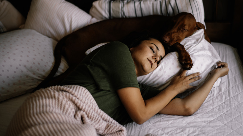 Dog and woman asleep in bed