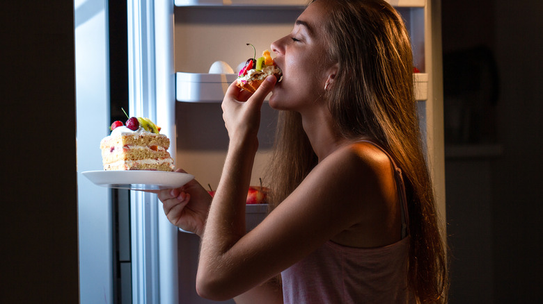 woman eating cake at night