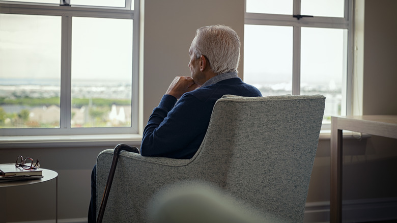 older man looking out window
