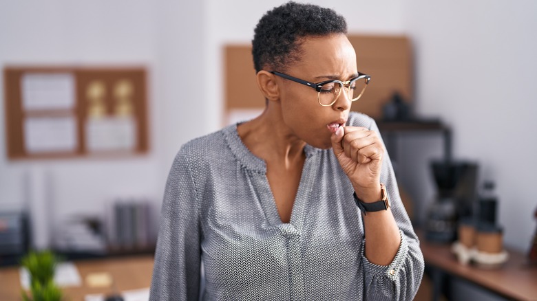 Woman coughing at work