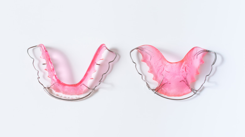 dentist holding retainers 