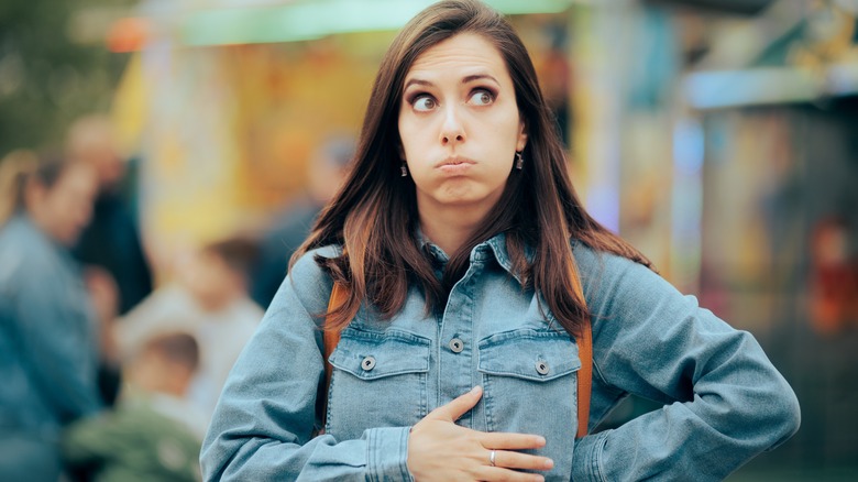 a woman with indegestion holds her stomach