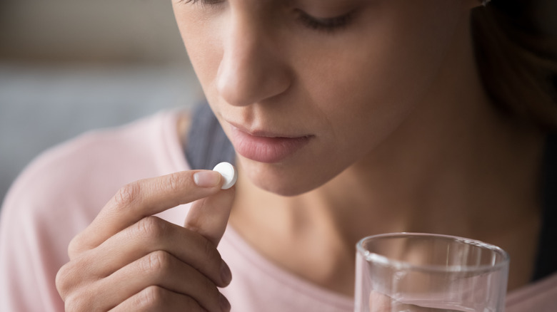 woman taking ibuprofen medication