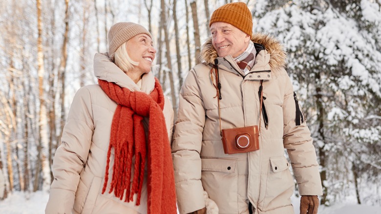 Happy senior couple walking in snow