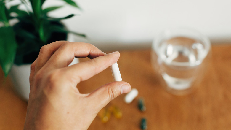 person holding magnesium supplement in their fingers