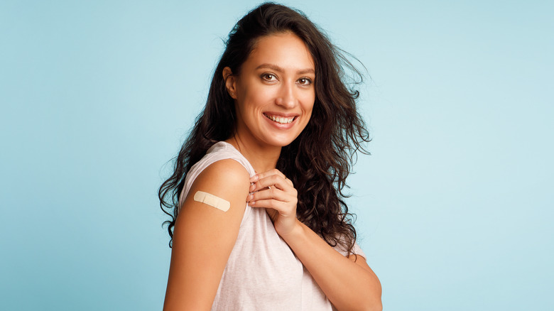 Woman showing arm with bandage after Covid-19 vaccine
