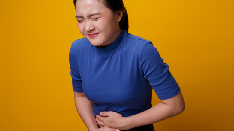 Women grabbing her stomach in pain