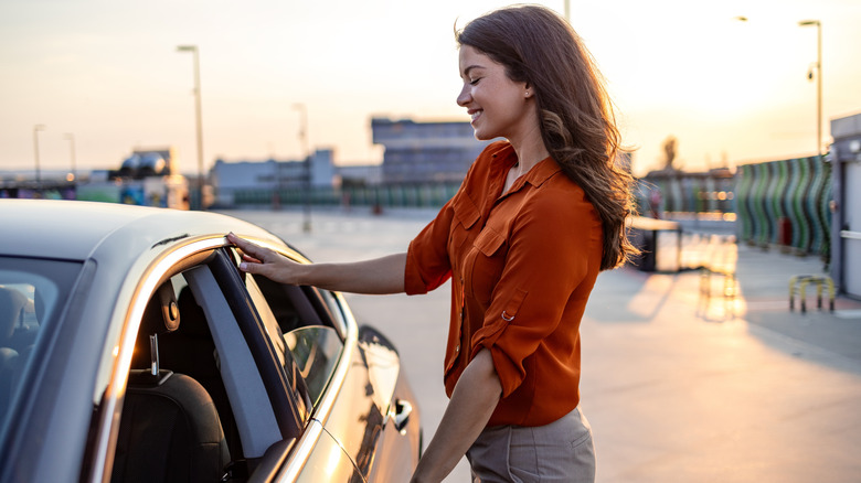 young woman getting into car