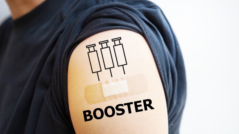 Man showing vaccinated shoulder with third shots or booster shots symbol, vaccination for COVID-19 concept