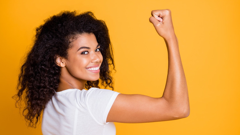 A woman flexes her arm