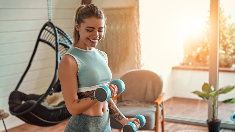 Woman lifting dumbbells at home